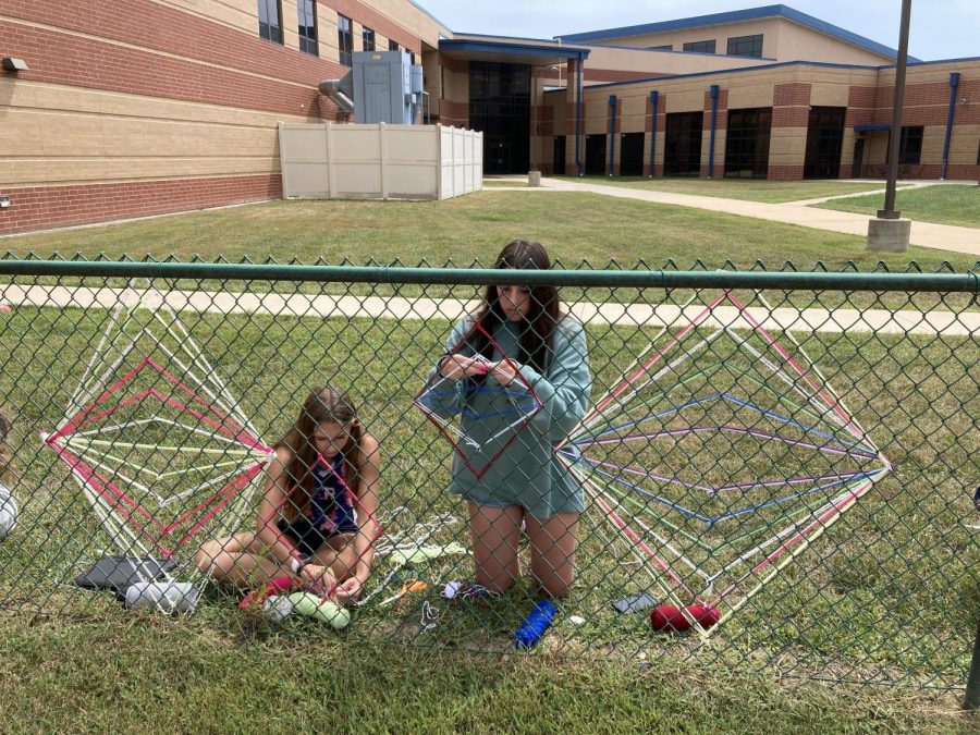 Emily Cumberland and Amanda Dudley work on their yarn art for the Liberty fence.