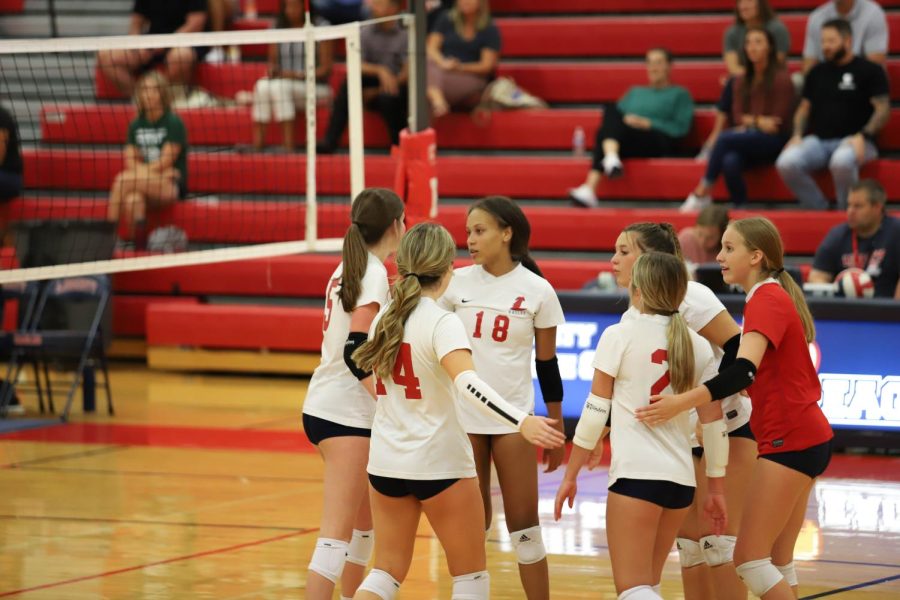 The JV volleyball team celebrates after a point. 