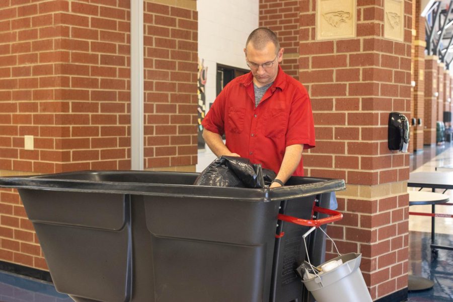 After a busy lunch, custodian Matt Boswell empties a trash bin. 
