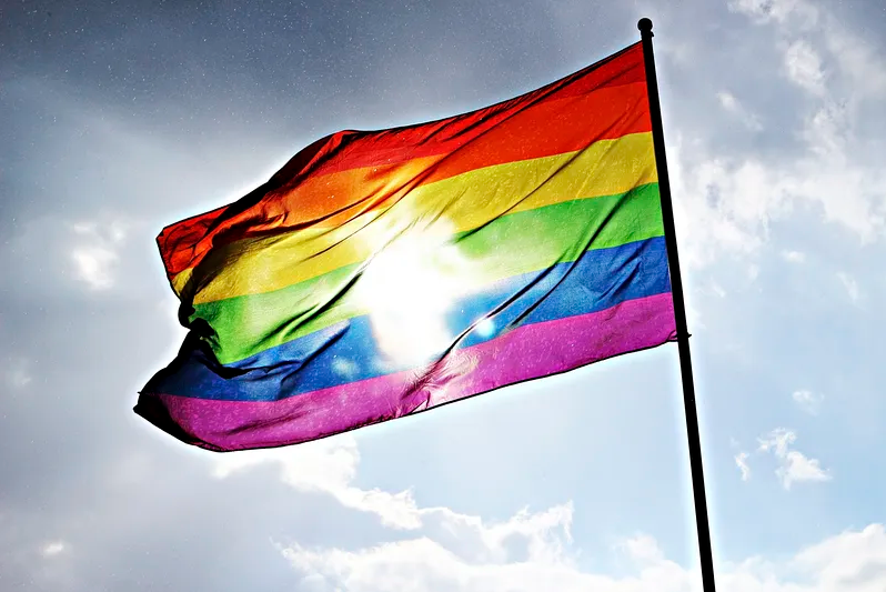 Sun+shines+through+onto+a+pride+flag+showing+the+light+of+positivity+and+unity.