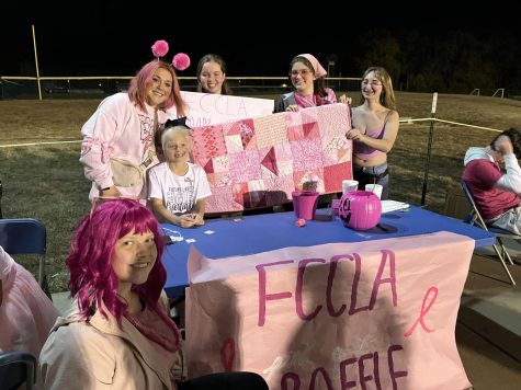 Liberty FCCLA members pose with their table selling raffle tickets for a handmade pink quilt.