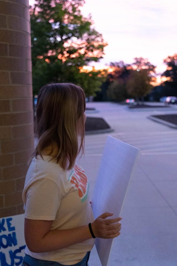 Sophomore Reese Bedford helps with the climate emergency petition at sunrise.