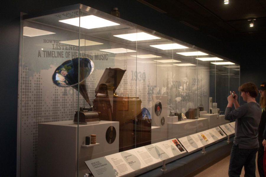 Keaton Franciskato takes a photo of the progression of music recording exhibit at the Missouri History Museum on Nov. 9.