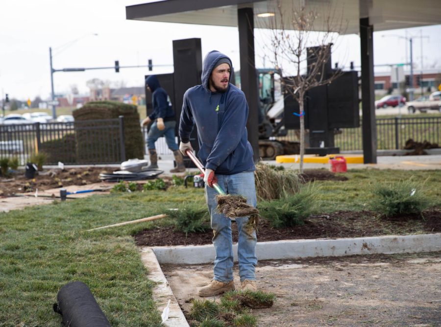 An Elevate Outdoor worker helps sod around the new building. 