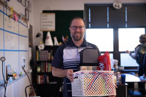 Mr. Barker stands in his classroom after receiving his Teacher of the Year gift basket.