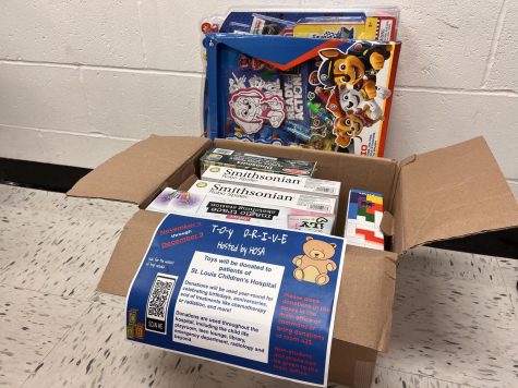A box containing donations to the toy drive sits in the hallway.