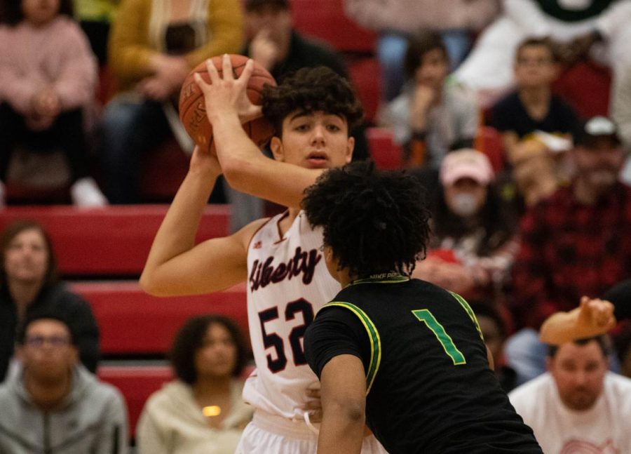 Sophomore+Andrew+Badra+looks+for+a+pass+as+he+clutches+onto+the+basketball%2C+guarding+it+from+a+contending+Fort+Zumwalt+North+player.
