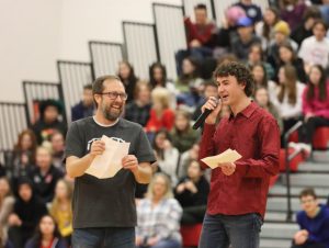(Left to right) Mr. Barker and co-host of the winter pep assembly, senior Aidan Berry, converse with one another after the staff and cheer dance performance. Mr. Barker was also congratulated in front of the school body for winning District Teacher of the Year. 