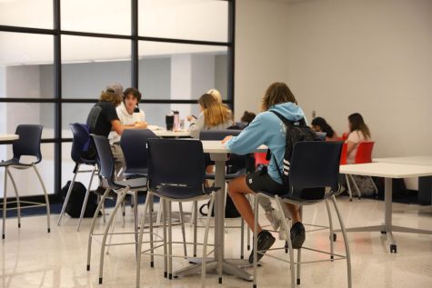 Students eat lunch in the commons at the beginning of the 200 hallway. 