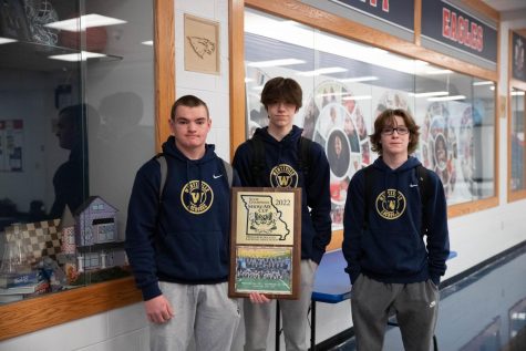 From left to right: junior Hagen Walch, sophomore Dante Benson and junior Mikey DiLorenzo pose with the state championship plaque that their lacrosse team attained last year.