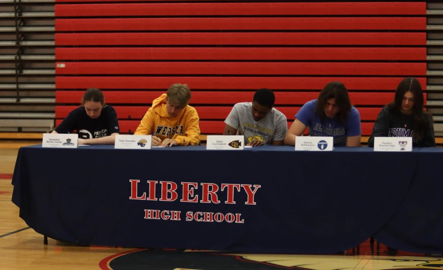 Samantha Borton-Center, Tyler Gonzalez, Blake Cunningham, Nate Bobikiewicz and Madalyn Breckenridge take a moment to sign their college letters. 