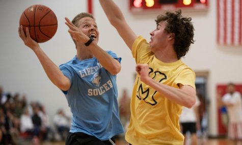 Coach Luedecke jumps up to shoot the ball with opponent Aidan Berry attempting to block the shot. Luedecke was the leading scorer for the staff. 