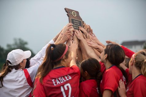 The team holds the first-place district plaque after defeating Francis Howell Central on May 19. 