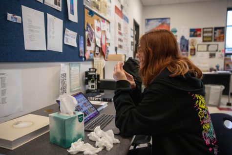 Senior Emily Hammock uses a tissue to help alleviate her allergy symptoms while doing her school work. 