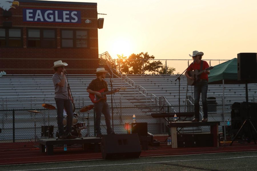Ryan Casteel (12) and 
Aidan Berry (12) and Ryan Casteel (12) both sing while Preston Allen (12) plays guitar in the middle.