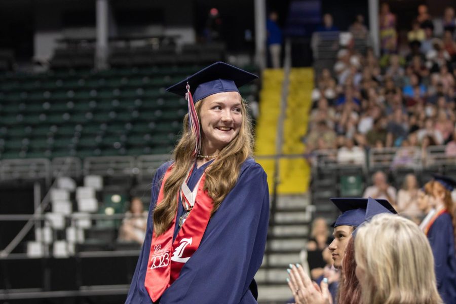 Graduating senior Audrey Beckhardt looks back at her friends and family as she stands up for recognition for her official seal of biliteracy. 
