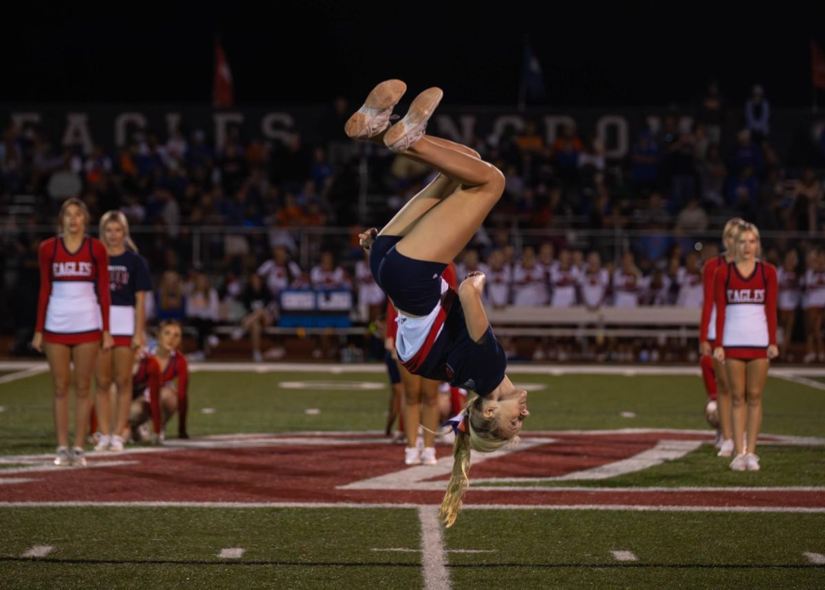 Senior Sophia Metheney does a backflip during the halftime cheer performance at the first home game of the season.