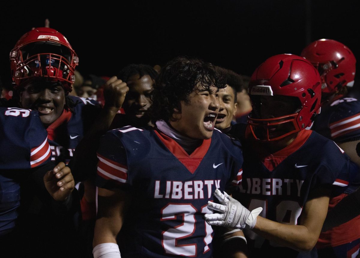 Senior Hy Vuong celebrates by cheering with his teammates after winning the game against North Point 29-27.
