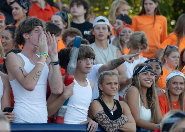 Jack Gnandt holds the spirit stick while the student section intensely watches the varsity football team game at Holt on Sept. 1.