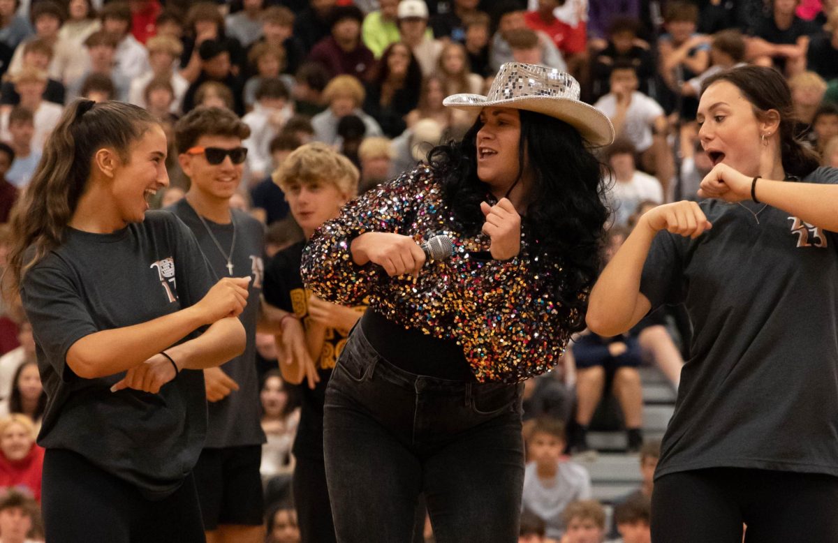 Ms. Kleiber dances with students during the homecoming assembly. 