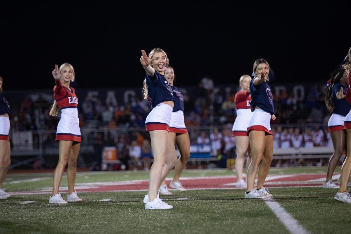 Seniors Alexa Popp and Carmen Brassel hold out Libertys L amidst cheers halftime performance. Sep. 8 served as cheers senior night. 