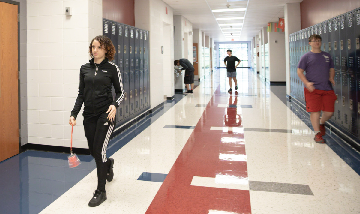 Freshman Ava Hall walks back to class in the 200 hallway while carrying the classroom bathroom pass. Each hallway bathroom is now color coded and students may only use that bathroom on that specific floor. 