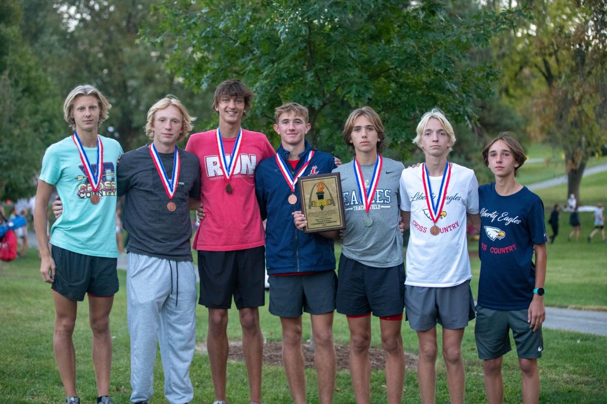 The boys varsity cross country team poses with their first-place plaque at GACs.
