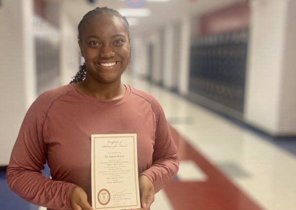 Vanessa Jackson smiles as she holds her acceptance letter from the Congress of Future Medical Leaders.