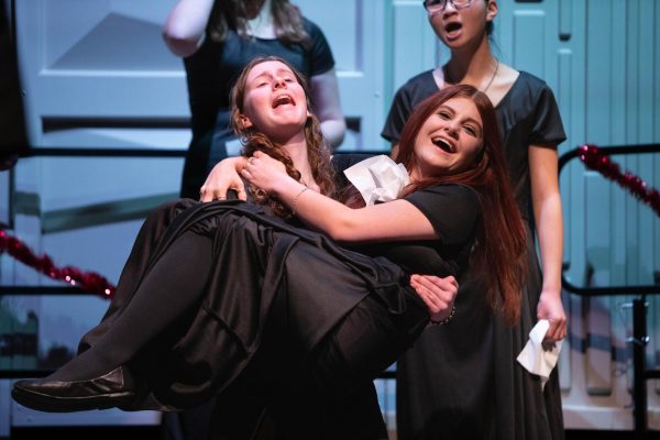 Freshman Marley Higlen holds fellow freshman Sage Kennedy during Select Treble Choirs performance of Cold and Fugue Season by J.S. Bach. This was one of over 20 songs performed by the various choirs during the winter concert held on Dec. 12.