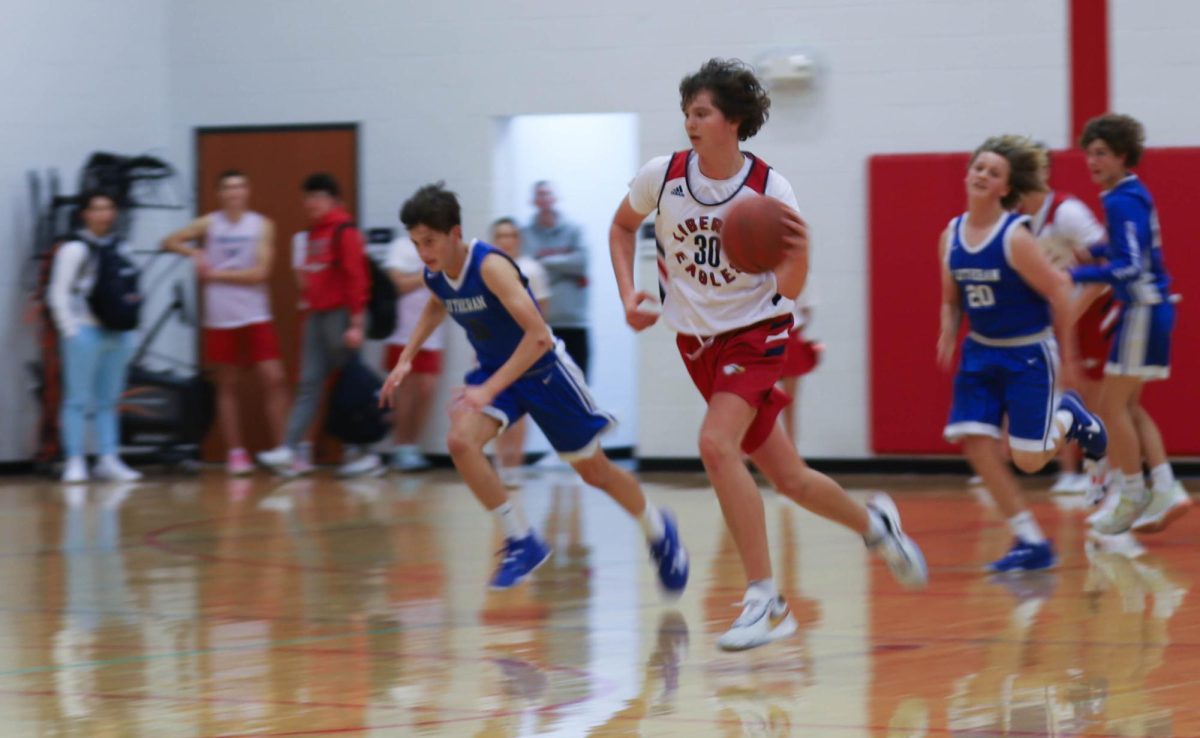 Hunter Holst races down the court in the second quarter against Lutheran High School.