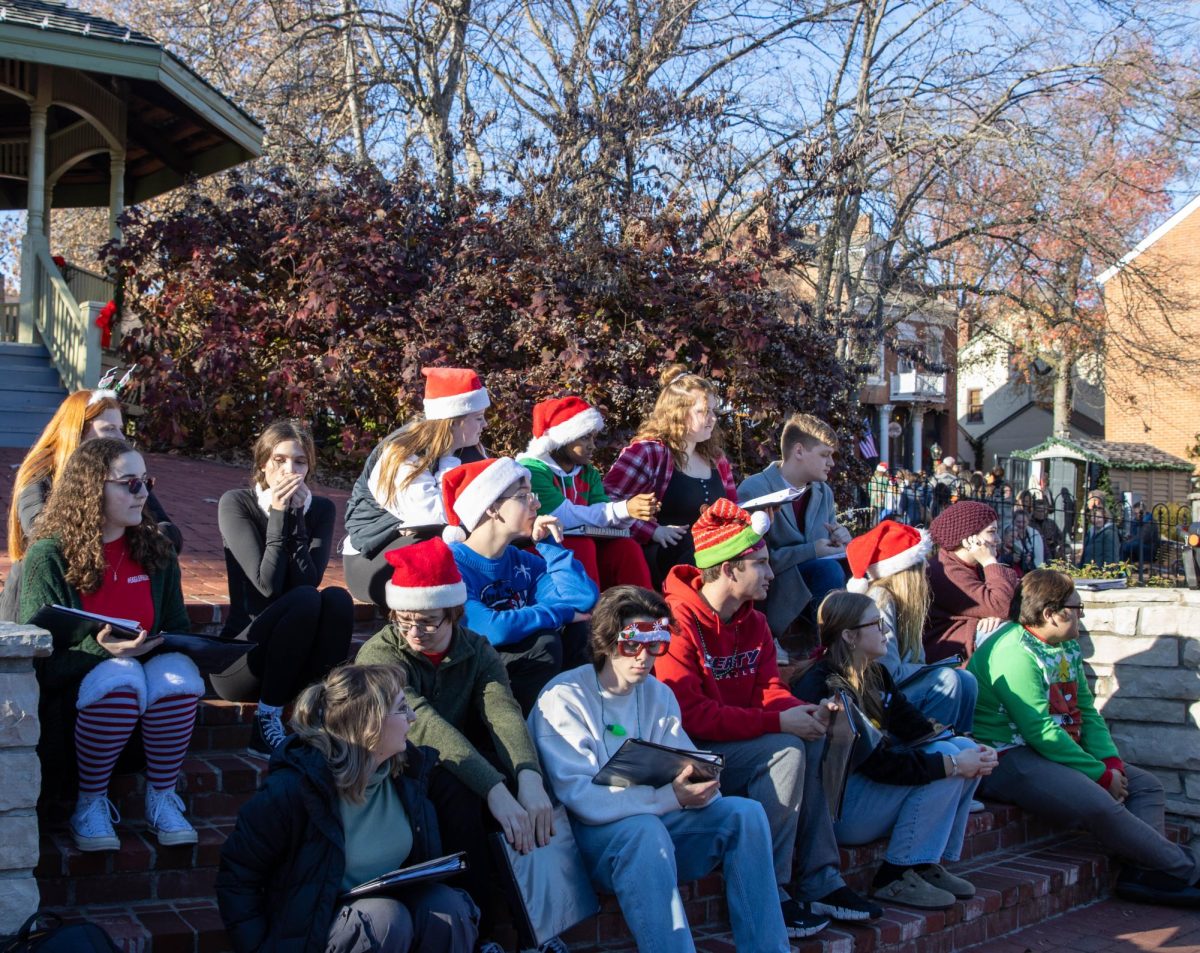 Students a part of chamber choir sit on the steps of the gazebo before their performance in Historic Main Street St. Charles.
