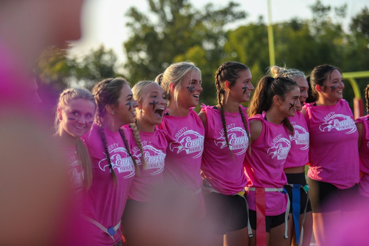 Senior girls dress in matching pink shirts loop arms and chant together, excited to play flag football against the junior girls. Seniors won on Libertys home field, for the first time in school history. The blinding joy the seniors and their coaches brough to powderpuff flag football had me excited, even as someone on the sideline. 