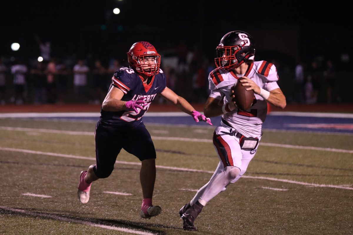 Junior Jack Ryan (#23) chases Fort Zumwalt South Bulldog (#2), attempting to tackle and gain possession of the ball. The theme of this game was pink-out, hence Ryans pink tape and gloves. This photo is so clear and it is cool how you can follow Ryans eyes to the player running from him.