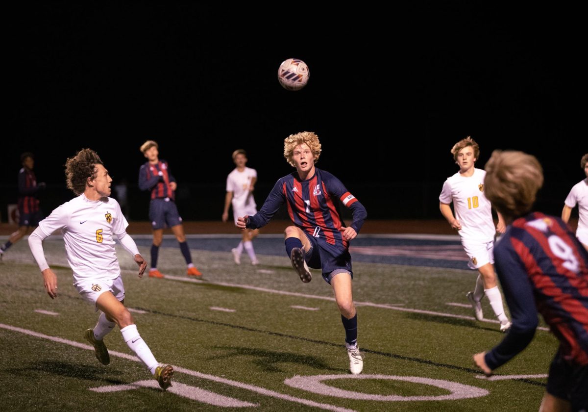 Senior Brady Freeman (#7) attempts to catch the ball on the inner arch of his foot and gain control of it, aiming his pass toward senior Canon Mathison (#9) during the game against Fort Zumwalt East High School on Oct. 17. Despite Liberty taking a 3-1 loss, the team celebrated 11 seniors on the night. The celebration began an hour before the game at 5 p.m. with the seniors walking the track being applauded and given gift bags. Soccer is one of my favorite sports to shoot, I am forever grateful that I caught this amazing moment on camera. 