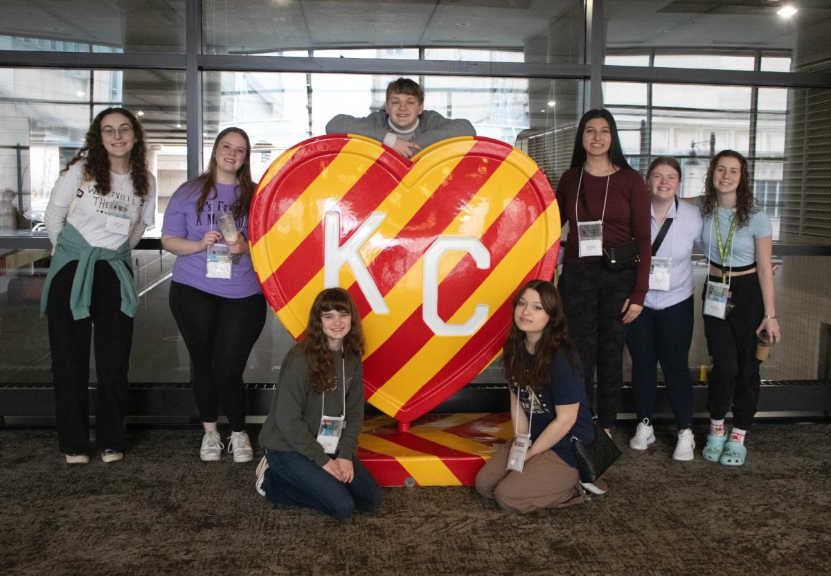 After attending workshops throughout the morning, several Liberty students pose with the red and yellow KC heart in the convention centre where many activities took place. 