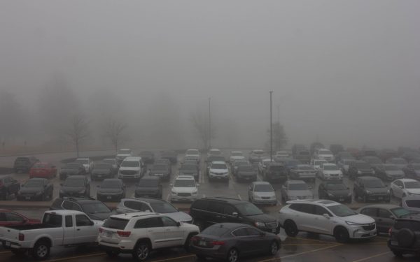 A layer of fog covers the parking lot, making the day feel shorter. Winter weather can lead to an increase in Seasonal Affective Disorder.