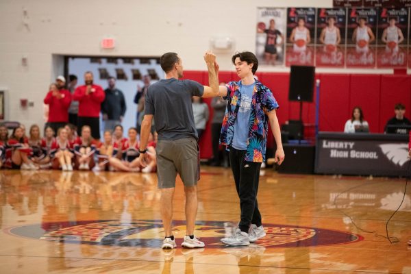 Mr. Sodamann goes in for a high five with senior Carter Ashby after an intense round of basketball during the annual Coaches vs. Cancer assembly. 