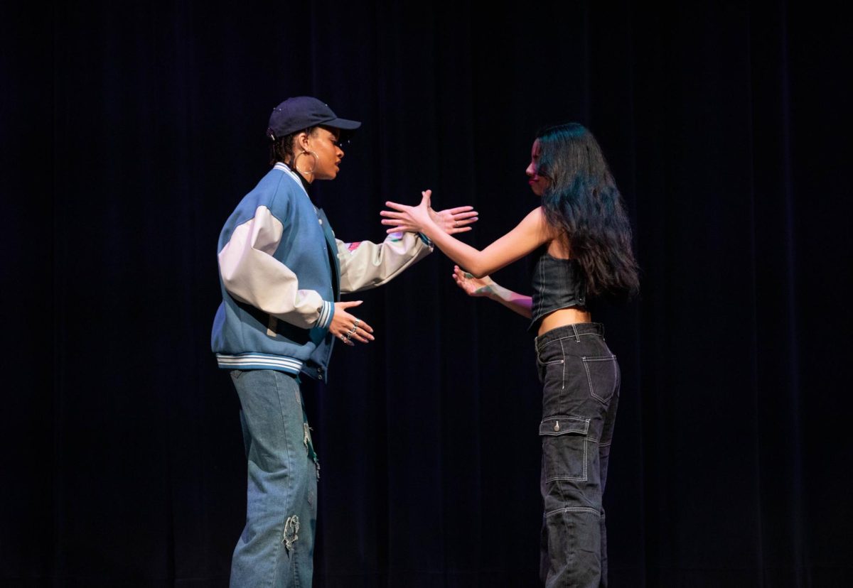 Seniors Alysha Sims and Narra Robles go to do a handshake during their performance at the talent show.