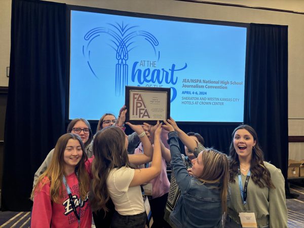During the opening ceremony of the Spring 2024 NSPA/JEA, members of LHS Publications proudly hold up the FAPFA plaque.