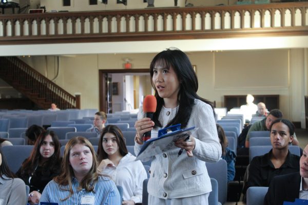 Emily Nguyen stands up to speak at Webster University, during one of their meetings
