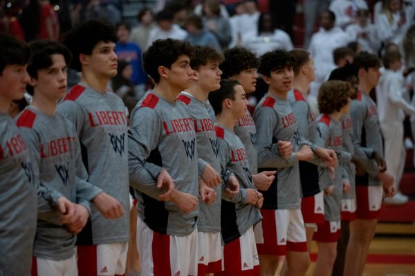 The boys varsity basketball team link arms while in a line before reciting the national anthem. They would go on to play Fort Zumwalt North and win with a score of 65-41.