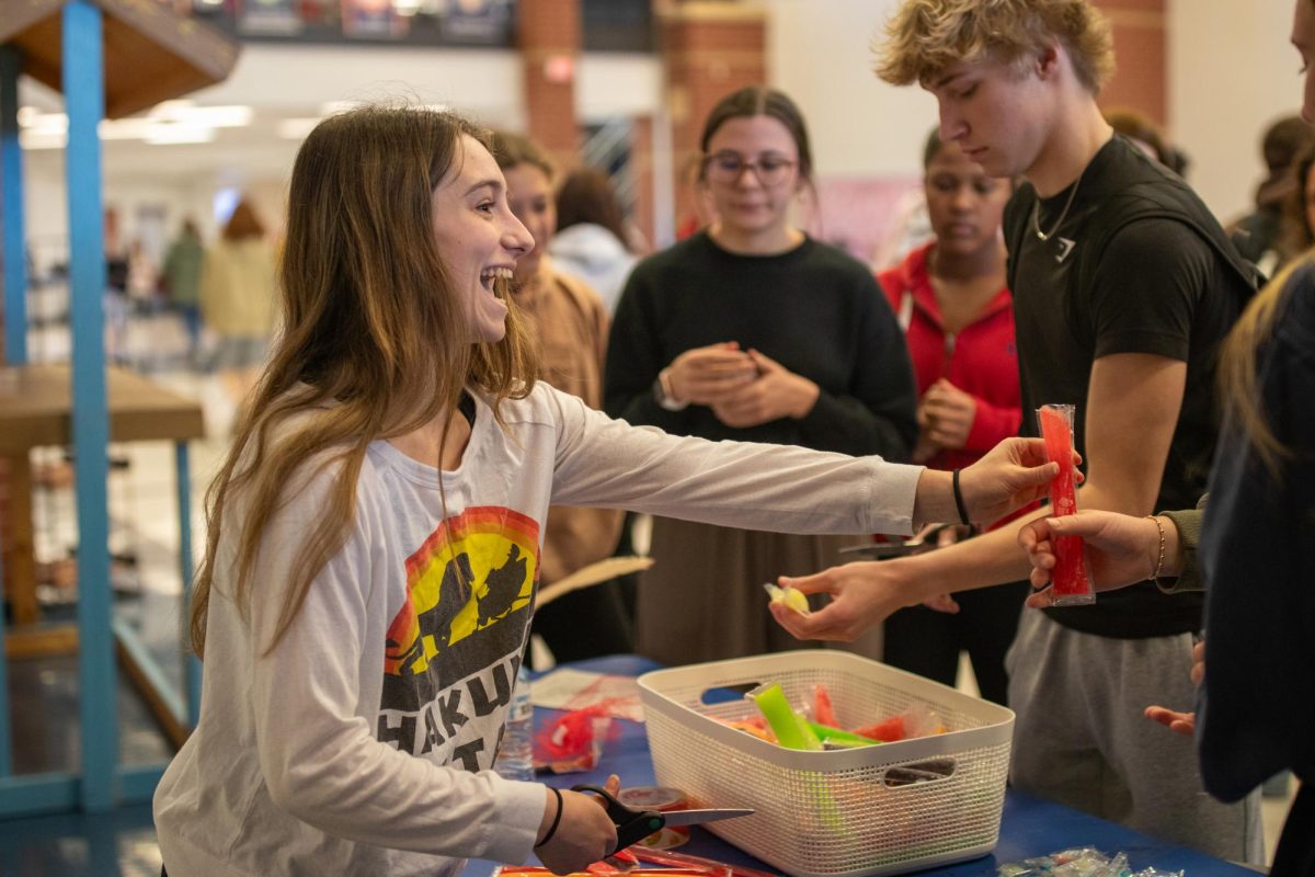 Delaney Hilgenbrink hands out popsicles during lunch to campaign on Wednesday.