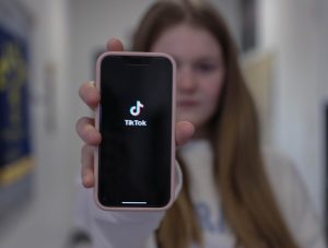 Austin Koehnemann holds up TikTok on her phone. The US House of Representatives passed a bill to force ByteDance to sell the popular app. 