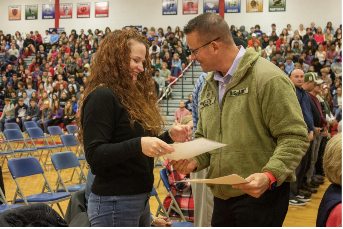 Mr. Nelson hands out awards to veterans for their service at a school assembly in November 2022. Nelson is a US Army veteran. 
