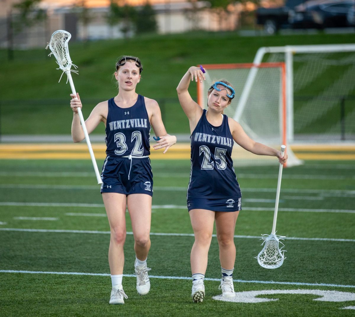 After a junior varsity lacrosse game against Cor Jesu, juniors Chloe Bostic and Lilly Brown pose as they walk off of the field. 