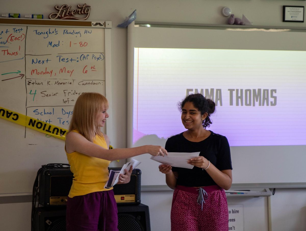 Lorelei Wise (10) gives Emma Thomas (12) her certificate.
