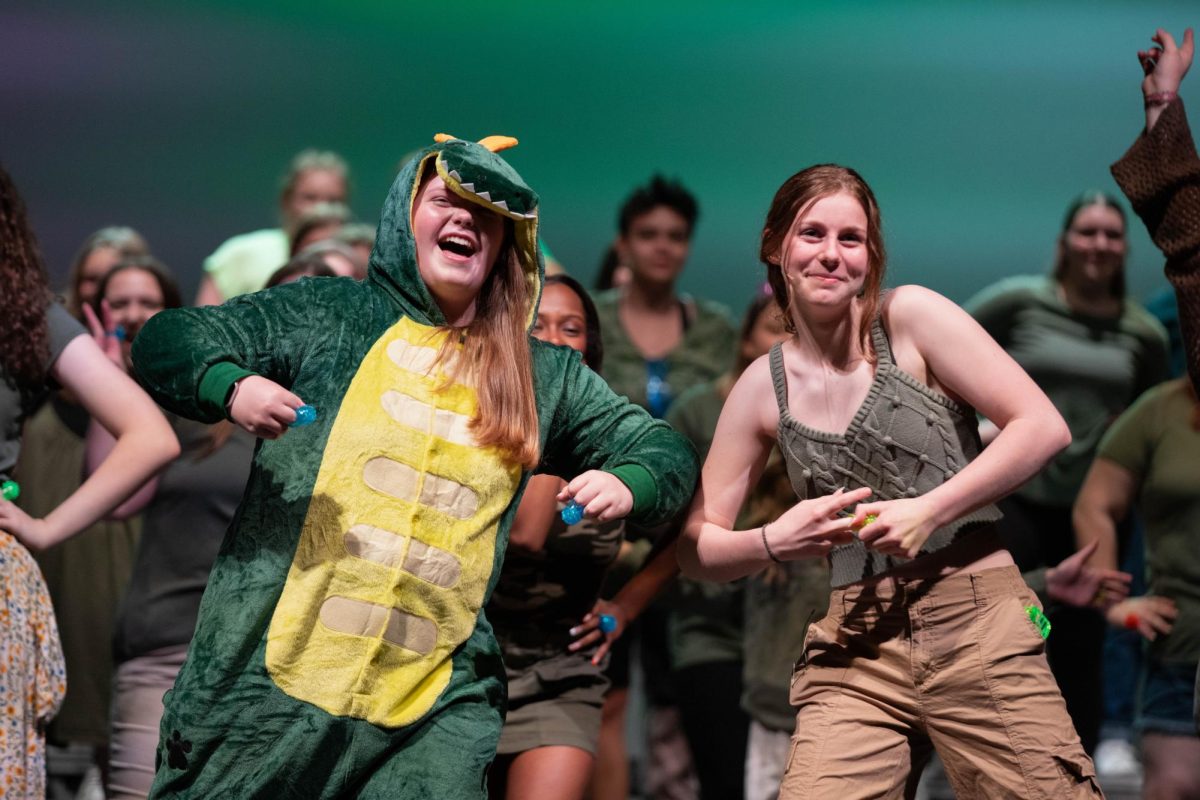 Sophomore Mak Barnes wears a crocodile onesie along side freshman Marley Higlen as they perform The Bare Necessities at the annual choir pop concert. 