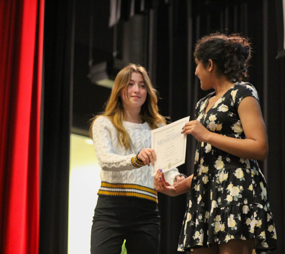 Senior, and former president of Key Club, Emma Thomas gives freshman Ellie Simon a membership certificate.