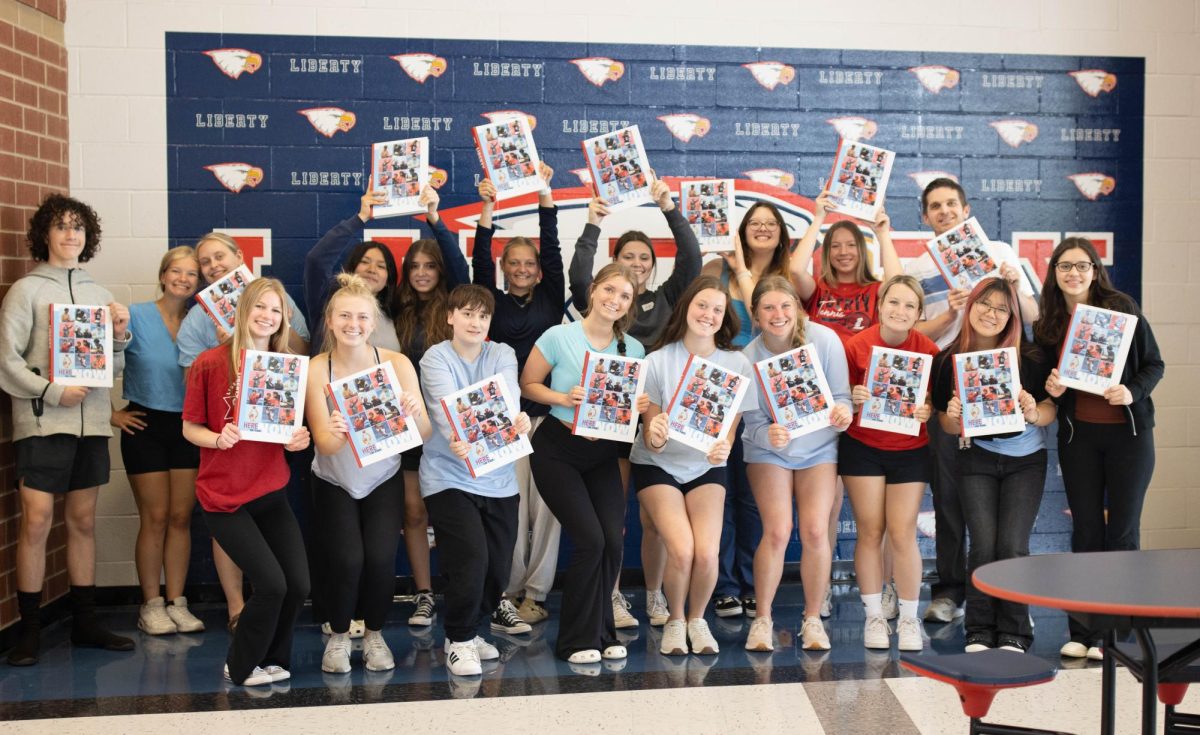 The 2024 Talon yearbook staff pose for a photo after they opened the first boxes when it arrived to school on May 3.