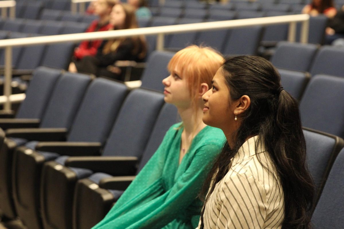 Sophomores Lorelei Wise and Loukya Vaka watch the annual Key Club video from the auditorium seats, after being inducted as new officers.